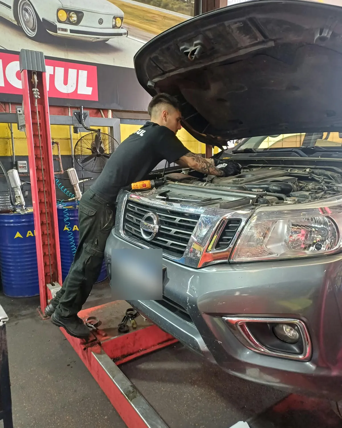 Mecánico de Indi revisando el motor de una camioneta en el box